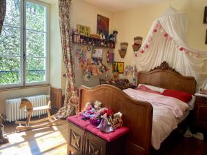 a bedroom with a canopy bed with stuffed animals on a table at Grande et belle demeure in Prez-sous-Lafauche