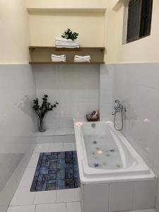 a white bathroom with a bath tub in it at The Mandarin Inn in Gilgit