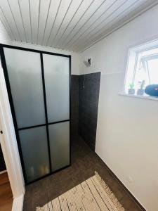 a bathroom with a shower with a glass door at The Old Hotel Silkeborg - S1 in Silkeborg
