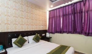 a bedroom with a bed and a purple window at Hotel Pacific Blu in Lucknow