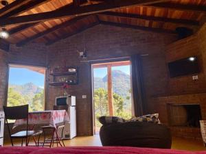 Una sala de estar con vista a la montaña. en Chalé Pedra Chanfrada 02, en Gonçalves