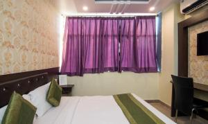 a bedroom with a bed and a purple window at Hotel Pacific Blu in Lucknow