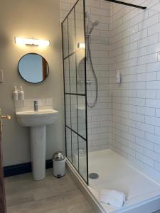 La salle de bains est pourvue d'une douche et d'un lavabo. dans l'établissement The Kings Arms Temple Sowerby, à Temple Sowerby