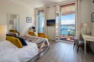 Habitación de hotel con cama y balcón en Hotel Suisse, en Niza