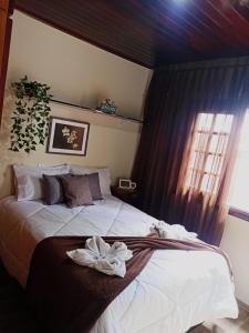 a bedroom with a bed with a towel on it at Vilarejo da Esperanza in Campos do Jordão