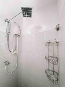 ein weißes Bad mit einer Dusche und einem Waschbecken in der Unterkunft hei apartment in Bacolod City