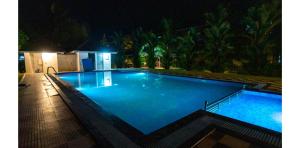 a large swimming pool at night with blue illumination at Kumarakom Heritage Resort & Ayurveda in Alleppey