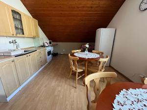 a kitchen with a table and chairs and a refrigerator at Penzión D+D in Zázrivá