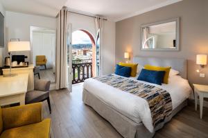 a hotel room with a bed and a desk and a window at Hotel Suisse in Nice