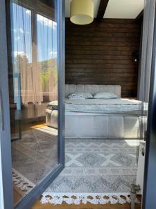 uma vista para um quarto com uma cama através de uma porta de vidro em Girske Povitria 2 em Yaremche