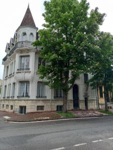 un edificio blanco con un árbol delante en Studio 11 Bis, en Vichy
