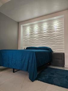 Un dormitorio con una cama azul y una ventana en Nala's Studio en Mayagüez