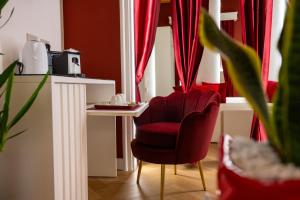 a living room with a red chair and a table at La Divina - free parking - in Tropea