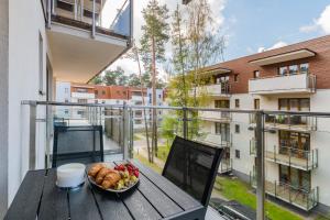 un plato de comida en una mesa en un balcón en APARTAMENTY MIERZEJA - BALTIC PARK STEGNA, Studio 24m2, 500 m od plaży, Bezpłatny Meleks, en Stegna