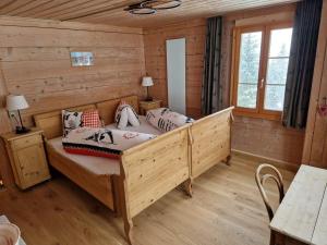 a bedroom with a bed in a log cabin at Alpenruh Kiental in Griesalp