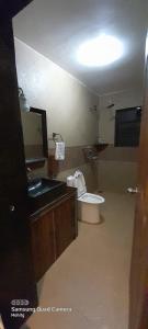 een badkamer met een wastafel, een toilet en een spiegel bij Villa Agastya in Betalbatim