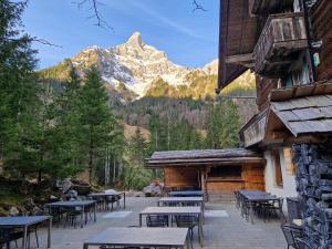 a patio with tables and chairs and a mountain at Alpenruh Kiental in Griesalp