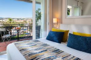 a bedroom with a bed and a balcony with a view at Hotel Suisse in Nice