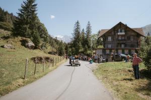 a person riding a motorcycle down a road in front of a house at Alpenruh Kiental in Griesalp