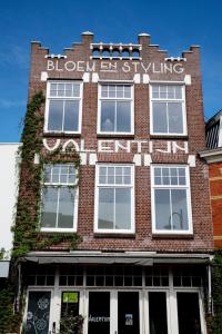 un edificio de ladrillo rojo con un cartel. en Stadslogement Valentijn en Sneek