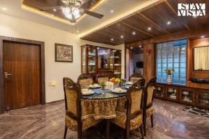 a dining room with a table and chairs at StayVista's Grace & Light - Hill-view villa with Outdoor pool, Terrace & Games room in Panchgani