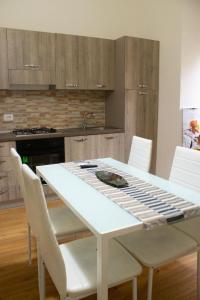 cocina con mesa blanca y sillas blancas en Guest House Civico 513 Casa Vacanze Reggio Calabria, en Reggio Calabria