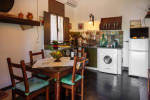 a kitchen with a table and chairs and a washing machine at La Virgy per Noto with share swimming pool with woderful seaview in Avola