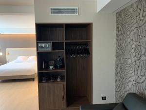 a bedroom with a bed and a book shelf with wine glasses at Best Western Plus Metz Technopole in Metz