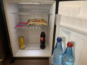 an open refrigerator with two bottles of soda at Best Western Plus Metz Technopole in Metz