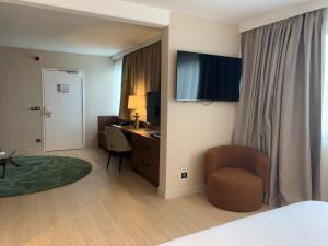 a hotel room with a bed and a desk and a chair at Best Western Plus Metz Technopole in Metz