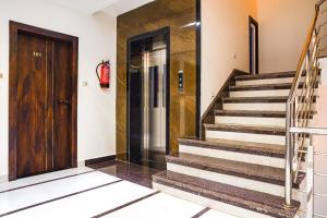 a hallway with stairs and a wooden door at FabHotel Lotus Blue in Bhopal