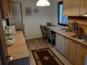 a kitchen with a counter and a table with chairs at Casa Velana in Gărâna