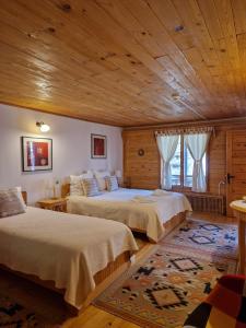 sypialnia z 2 łóżkami i drewnianym sufitem w obiekcie Casa Tisaru w mieście Lepşa