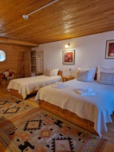 sypialnia z 2 łóżkami i drewnianym sufitem w obiekcie Casa Tisaru w mieście Lepşa