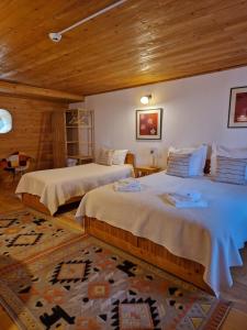 a bedroom with two beds and a wooden ceiling at Casa Tisaru in Lepşa