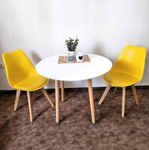 una mesa con dos sillas amarillas y una mesa con un jarrón en Studio Centrum, Private Entrance, SELF CHECK-IN 24h en Katowice