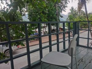 a table and a chair sitting on a balcony at 乐居fortunate angle in Luang Prabang