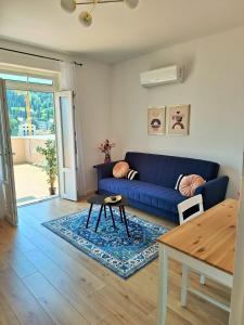 Una sala de estar con un sofá azul y una mesa. en Villa Blue Promenade, en Dubrovnik