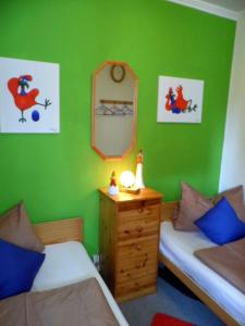 um quarto verde com 2 camas e um espelho em Brockenhexe em Altenau