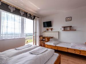 2 camas en una habitación con ventana grande en Pokoje u Chmielaków - Huba, en Maniowy