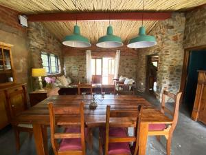 a dining room with a wooden table and chairs at The Riverdeck Accommodation and Backpackers in Knysna