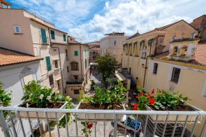 an apartment balcony with flowers on a city street at La Divina - free parking - in Tropea +157 photos