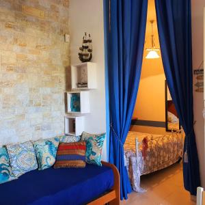 un soggiorno con tende blu e divano di Salento - A Casa di Lilli a Porto Cesareo