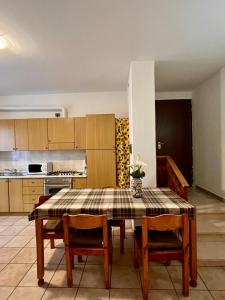 uma cozinha com uma mesa e 2 cadeiras e uma cozinha com uma mesa e cadeiras em Perla house em Abbadia Lariana