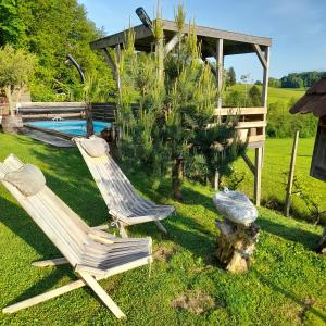 a couple of chairs in a yard with a pool at Apartma Lavanda in Dramlje
