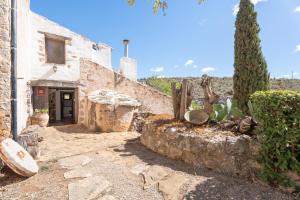 an entrance to a stone building with a tree at Moli Colomer in La Torre d'En Besora