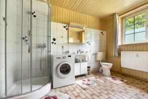 a bathroom with a shower and a washing machine at Grosszügiges Ferienhaus mit Wald in Gerdau +18 photos