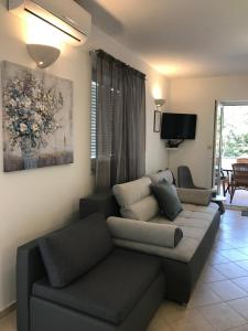 un soggiorno con divano e TV di Apartmani Samec a Novalja (Novaglia)