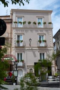 a building with potted plants on the balconies at La Divina - free parking - in Tropea