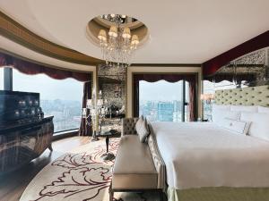 a bedroom with a large bed and a chandelier at The Reverie Saigon in Ho Chi Minh City
